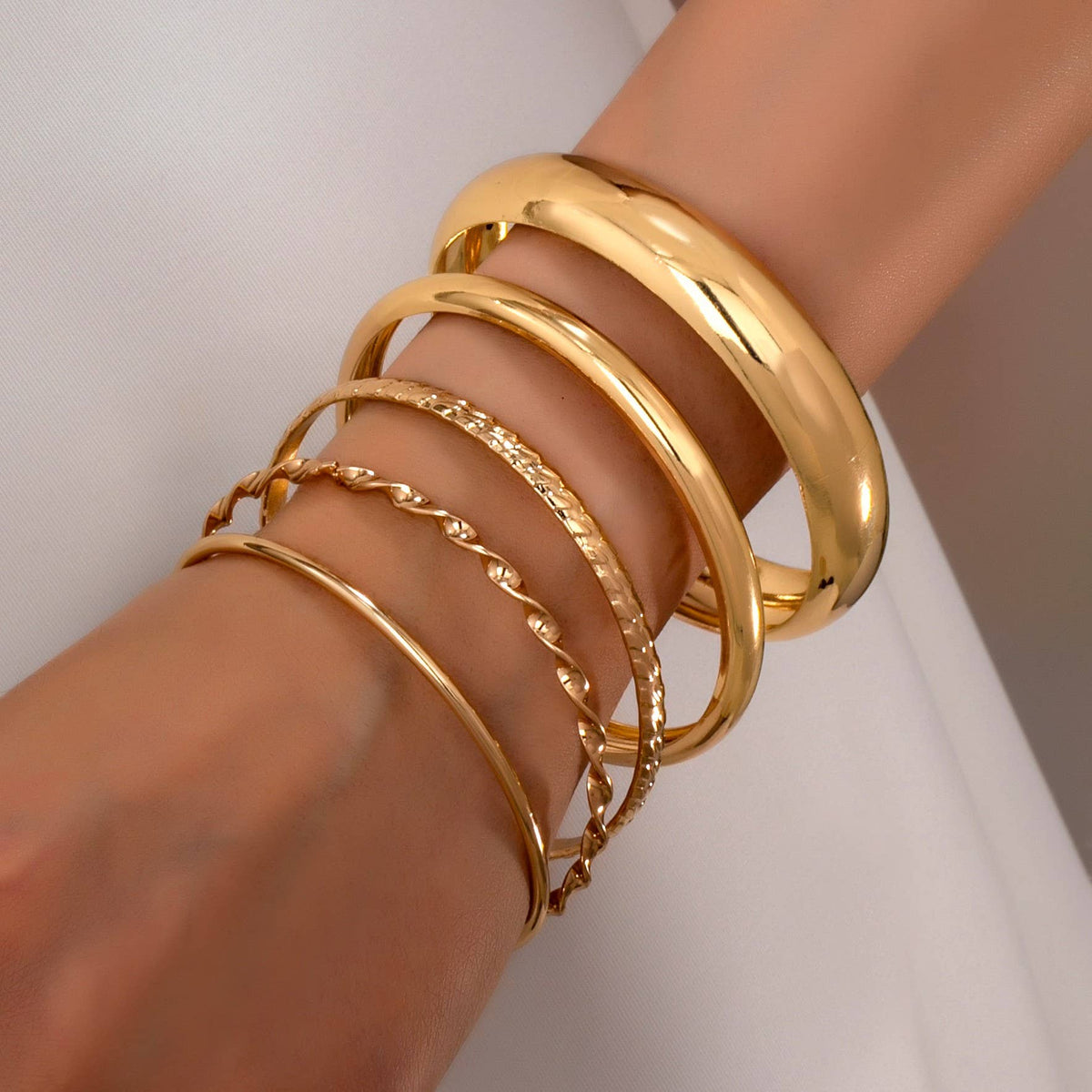Conjunto de brazaletes apilables texturizados dorados